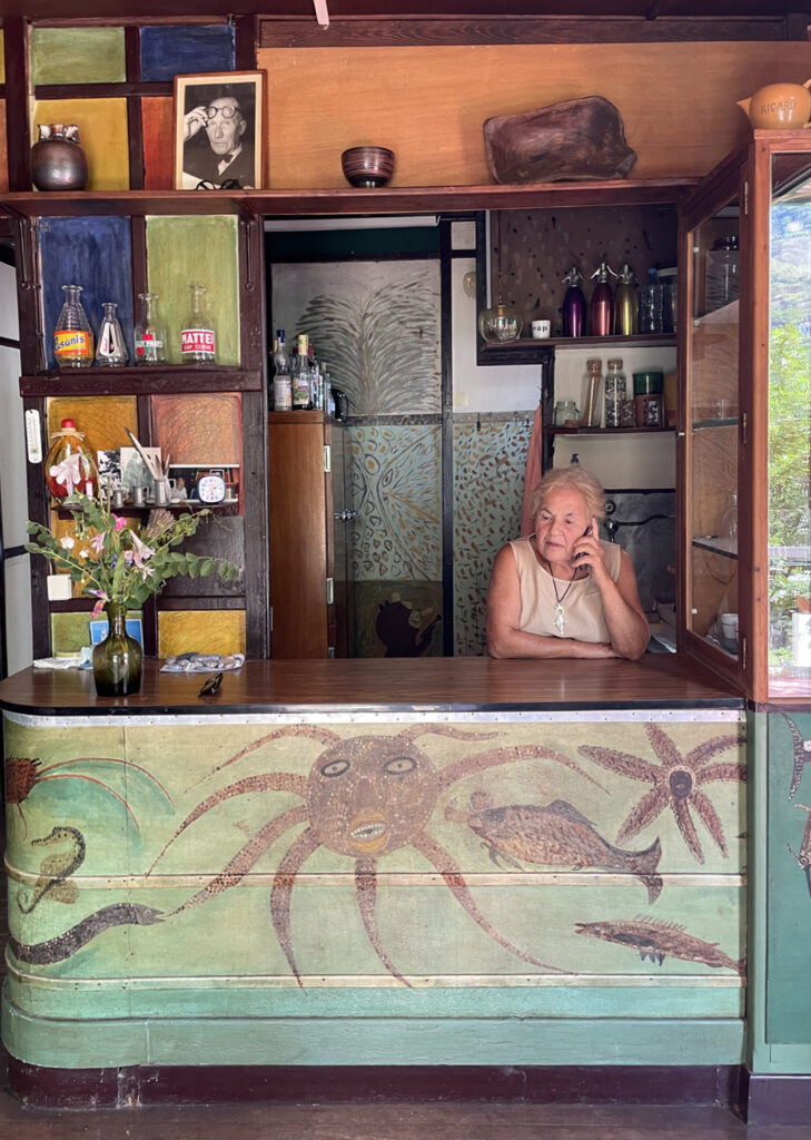 Magda Rebutato, accoudée au bar de l’Étoile de mer peint par Thomas Rebutato. Photographie © Milena Charbit, 2020.